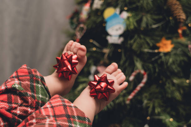 istock Baby bare feets with bow near the Christmas tree 1815152700