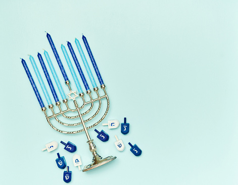 Hanukkah background with menorah and dreidel on a blue background