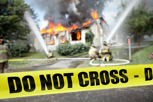 Do not cross tape with firefighters and a burning house stock photo