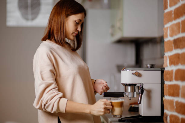 istock Beautiful woman preparing coffee in coffee machine at home 1815197972