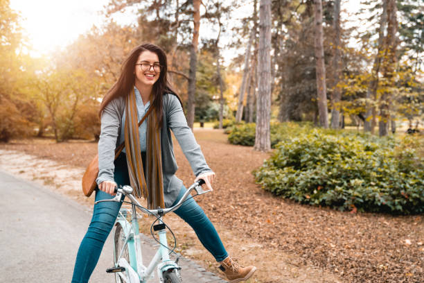 istock Cheerful young woman having fun while riding bike in public park during daytime 1815200072