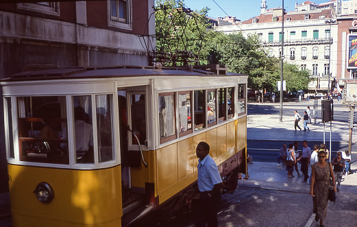 Lisbon, Portugal - aug 13, 1993:  view of a characteristic historic yellow tramway circulating through the ancient and steep streets of Lisbon
