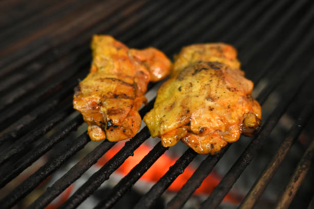 istock chicken with greens and vegetables roasting on a charcoal barbecue lit wood with fire for roasting chicken on the grill 1815219691