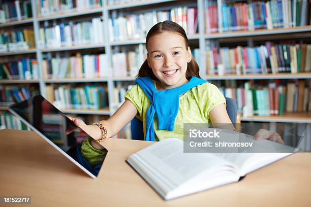 Schoolgirl In Library With Book And Tablet Stock Photo - Download Image Now - Book, Child, Digital Tablet