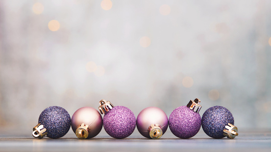 Christmas background with pink and purple glittery ornaments and space for text
