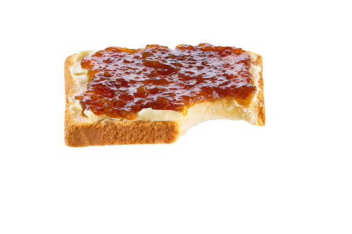 Take a bite toasted bread with figs jam and butter, isolated on a white. Slice of toast with bite missing.