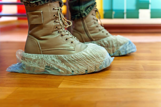 istock Feet in high boots and shoe covers 1815262296