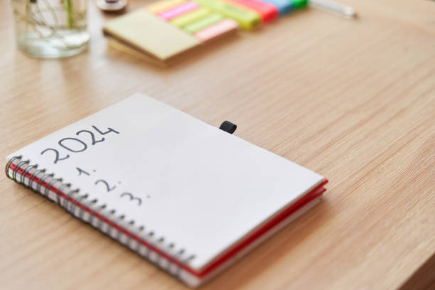 istock notebook with 2024 new year's resolutions and goals list by post it and pothos plant over wooden table 1815262833