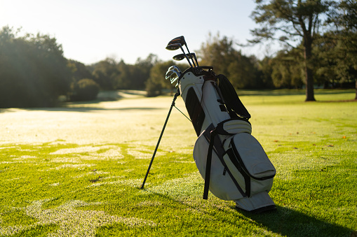 Tranquil scene of a golf bag with golf clubs inside in a green court