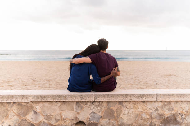 istock unrecognizable couple sitting on the beach 1815276401