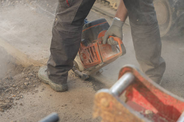 istock Worker using a motorized asphalt cutter or saw with round blade to cut through the asphalt ground as a process of renovation or remedy of a problem. 1815284571
