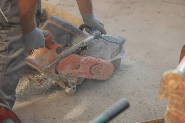 istock Worker using a motorized asphalt cutter or saw with round blade to cut through the asphalt ground as a process of renovation or remedy of a problem. 1815284579