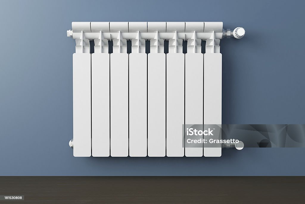 White heating radiator Heating radiator in a room with laminated wooden floor Radiator - Heater Stock Photo