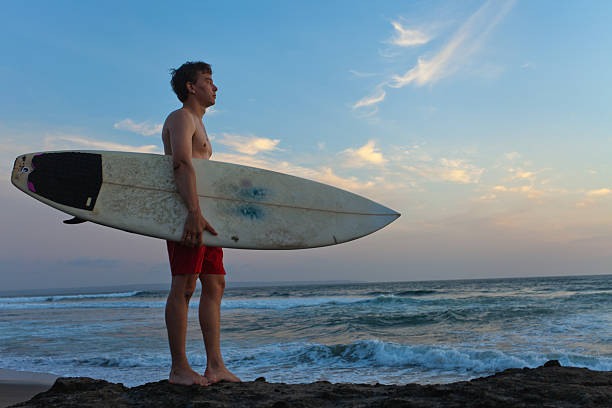 istock Man surfer with surfboard on a coastline. Bali. Indonesia 181530915