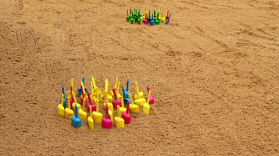 Colorful children's shovels in the sand.