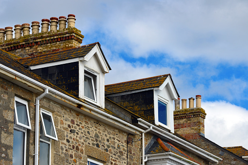 Marazion, Cornwall, England, UK: clay chimney pots and dormer windows on rooftops - Victorian row of terrace housing.