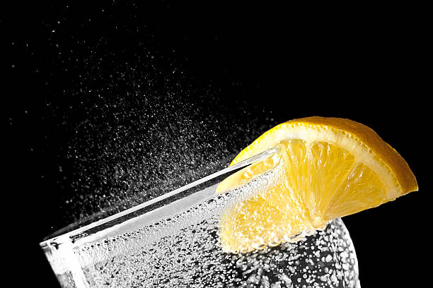 Sparkling water with an orange slice isolated on black backgroun stock photo