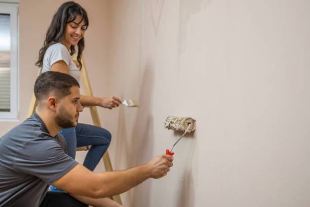 istock Young happy couple painting their new house interiors using paint rollers Home makeover and renovation concept 1815389815