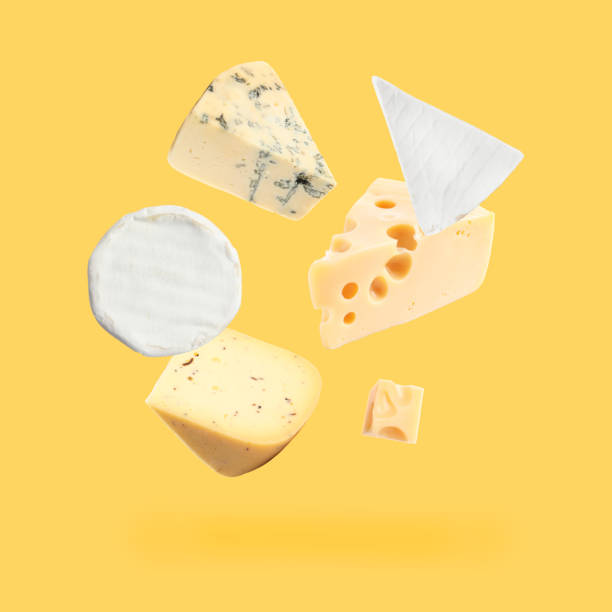 istock Different kinds of cheese falling on golden background 1815390358