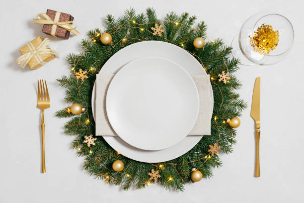 istock Christmas table setting with golden decorations and empty beige plate on white background. New Year table setting. Top view, flat lay. 1815391449