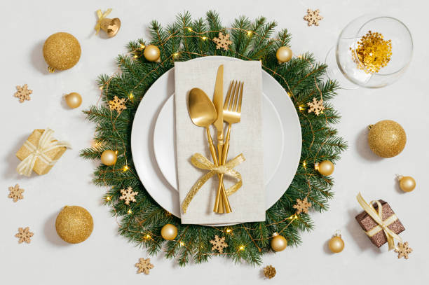 istock Festive table setting with Christmas wreath and golden decorations on white background. Preparation for Christmas dinner. Top view, flat lay. 1815391963