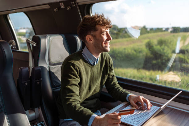 istock Young man with a credit card and a laptop. E commerce on the go. 1815393540
