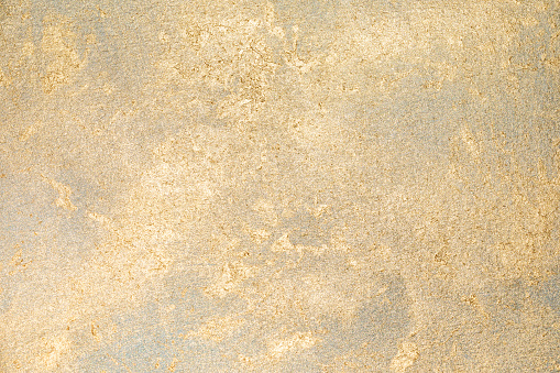 Golden paint on gold glitter paper.