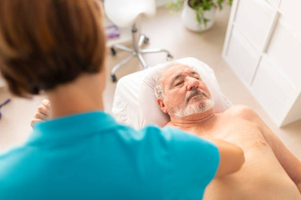 istock An older man, lying on the table in a physiotherapy clinic, during a manual therapy session with his physio 1815424303