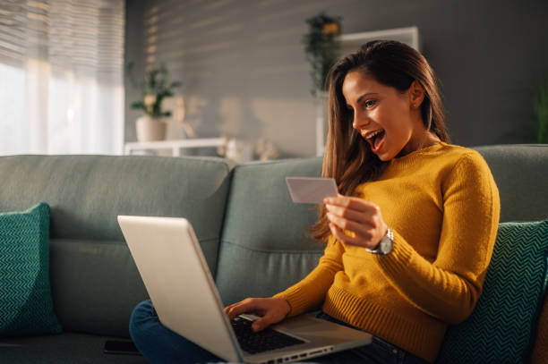istock An excited woman is looking at the credit card while using e-banking app. 1815434431