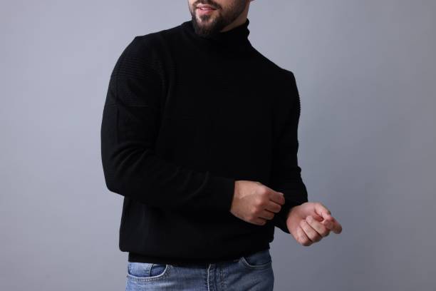 istock Man in stylish black sweater on grey background, closeup 1815470546