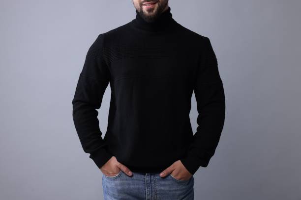 istock Man in stylish black sweater on grey background, closeup 1815476469