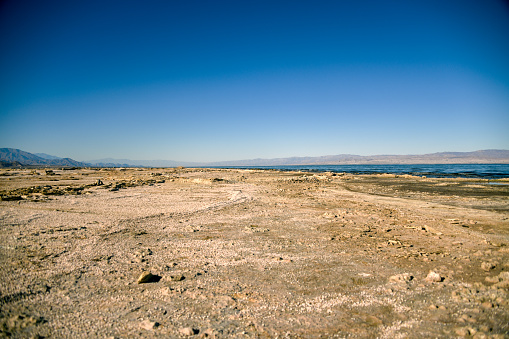 Wide shot of just how far the Salton Sea shoreline has receded revealing the dry lake bed below.