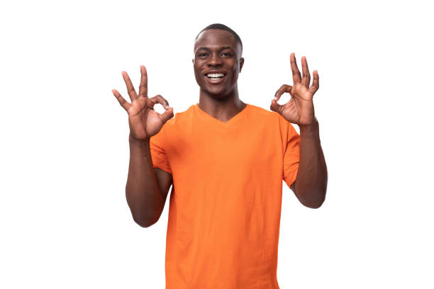 istock young american man in orange t-shirt feeling confident on white background with copy space 1815502910