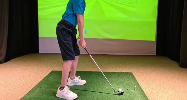 istock Handsome boy plays in a golf simulator indoors 1815503041