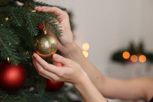 istock Woman decorating Christmas tree at home, closeup 1815513004
