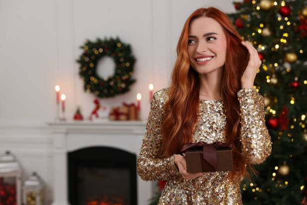 istock Happy young woman with Christmas gift at home, space for text 1815513534