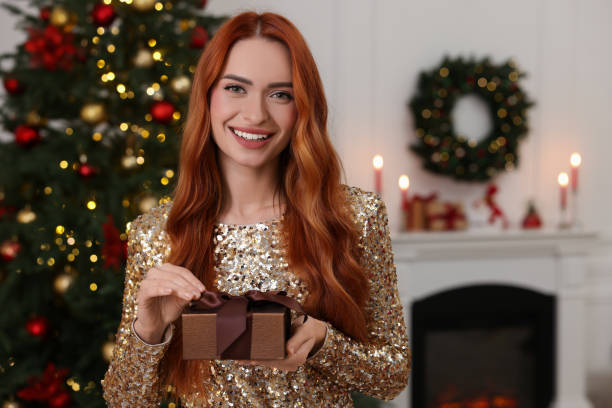 istock Happy young woman with Christmas gift at home, space for text 1815513539