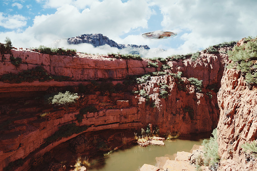 UFO flying over canyon. 3D generated image.