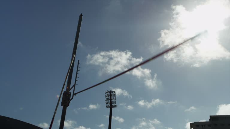 Female pole vaulter jumps and clears bar