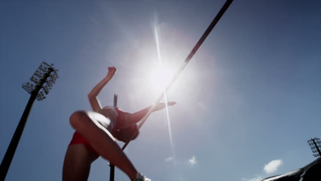 Female high jumper clipping bar
