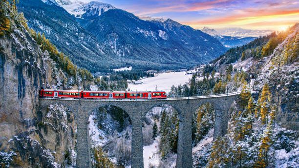 vista aerea del treno che passa attraverso la famosa montagna a filisur, svizzera. viadotto landwasser patrimonio mondiale con treno espresso nelle alpi svizzere scenario invernale neve. - european alps switzerland glacier high angle view foto e immagini stock