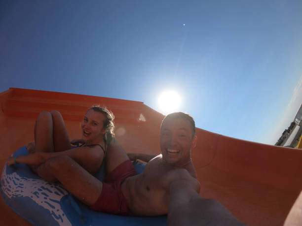 istock Happy couple having fun in water slides. Amusement, aqua. 1815545373