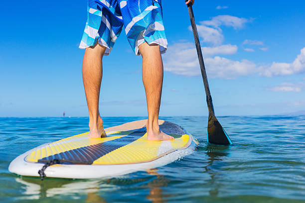 Man on Stand Up Paddle Board Young Attractive Mann on Stand Up Paddle Board, SUP, in the Blue Waters off Hawaii paddleboard surfing oar water sport stock pictures, royalty-free photos & images