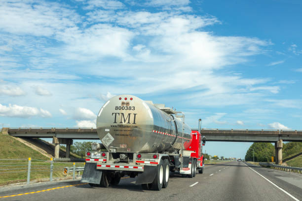 american large red tank truck at the highway overtaken by a prvate car - overtaken imagens e fotografias de stock