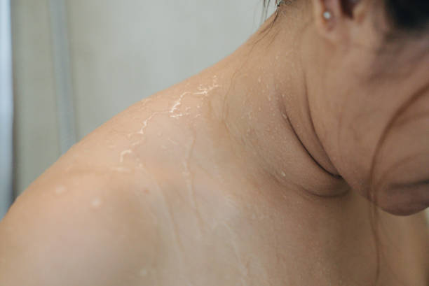 Close up of a woman showering in bathroom. Close up of a woman showering in bathroom. shower women falling water human face stock pictures, royalty-free photos & images