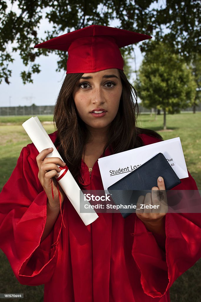 Student Loan Debt Concept Graduate holding diploma, checkbook and student loan bill. This is a conceptual image about student loans and debt. University Student Stock Photo