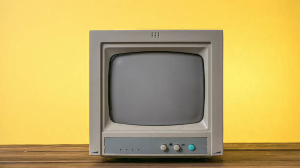 istock Mini retro TV on a wooden table on a yellow background. 1815707353