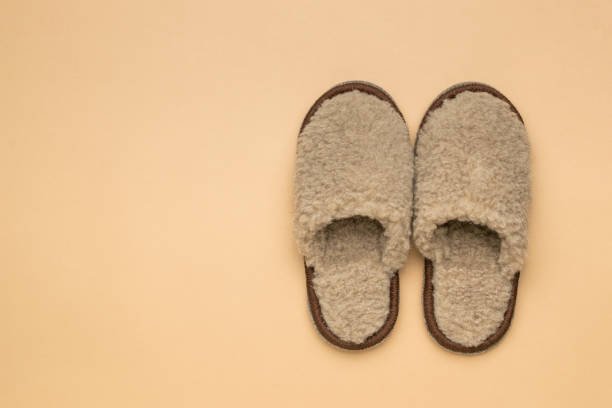 istock Homemade woolen slippers on a beige background. 1815707698