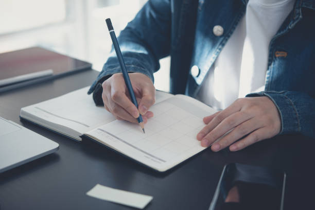 istock Event planner timetable agenda plan on year 2024 schedule event. Business woman checking planner on mobile phone, taking note on calendar desk on office table. Calendar event plan, work planning, mockup 1815725074