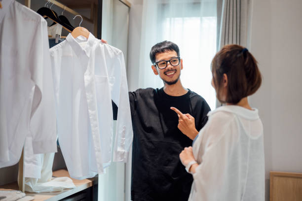 feliz pareja asiática eligiendo una ropa en casa - placard women holding standing fotografías e imágenes de stock